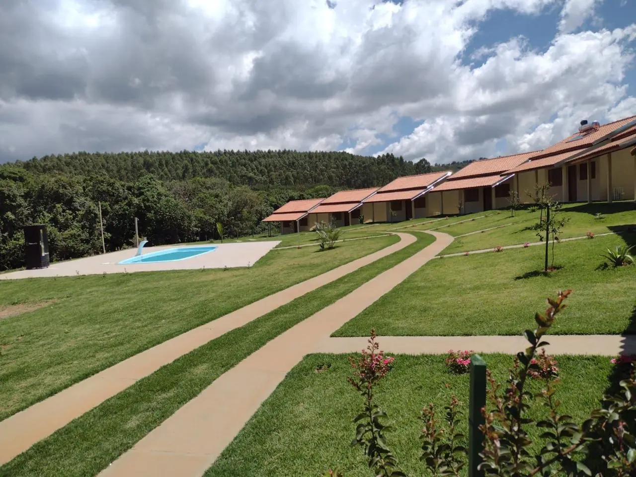 Caminhos de cimento cortando gramado em frente a chalés